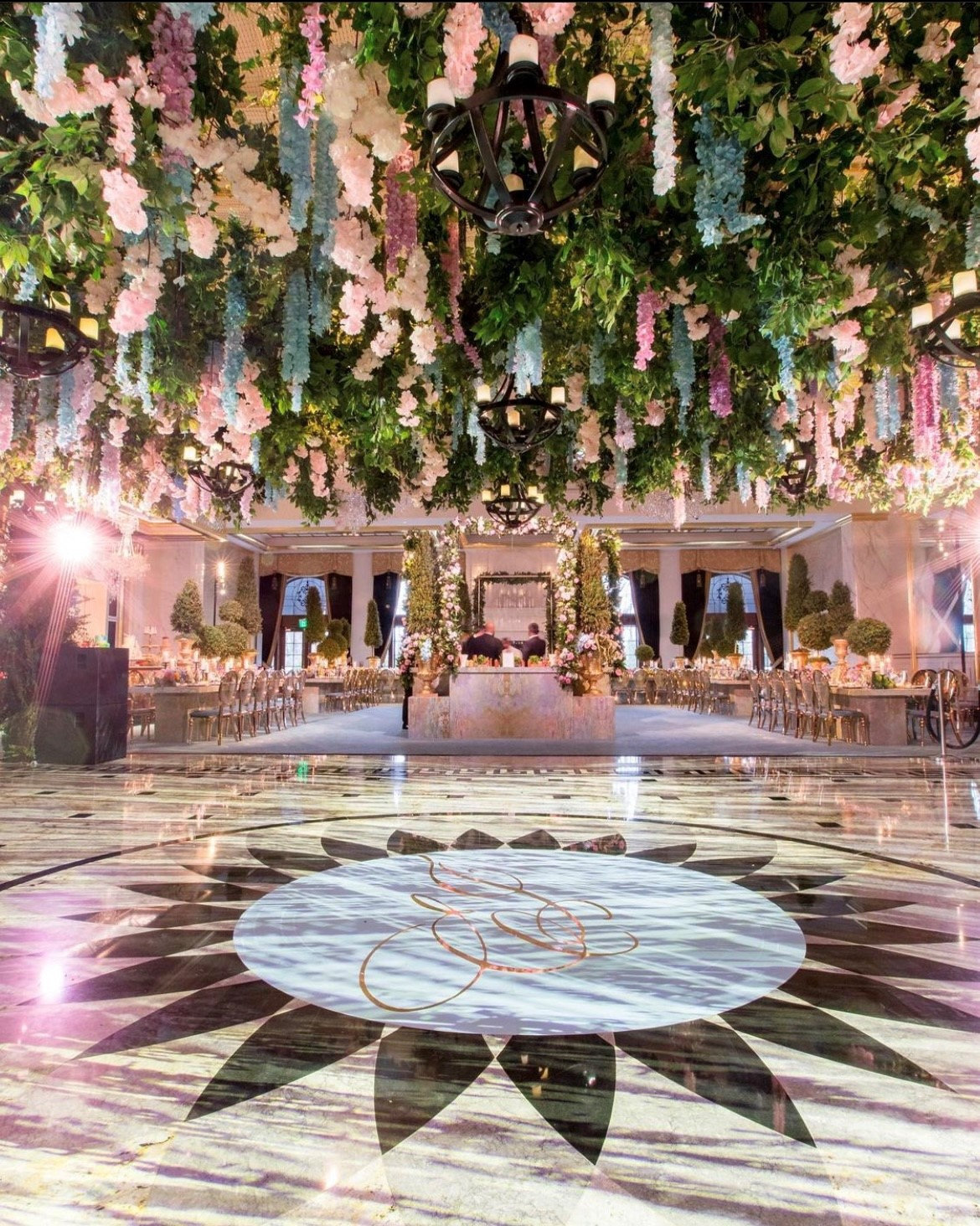 A dance floor beneath a hanging garden of wisteria