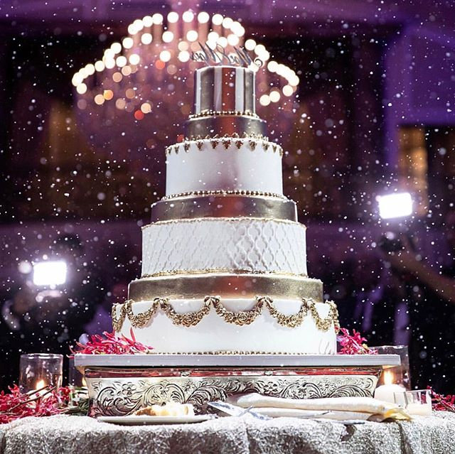 A tiered cake beneath a sparkling chandelier
