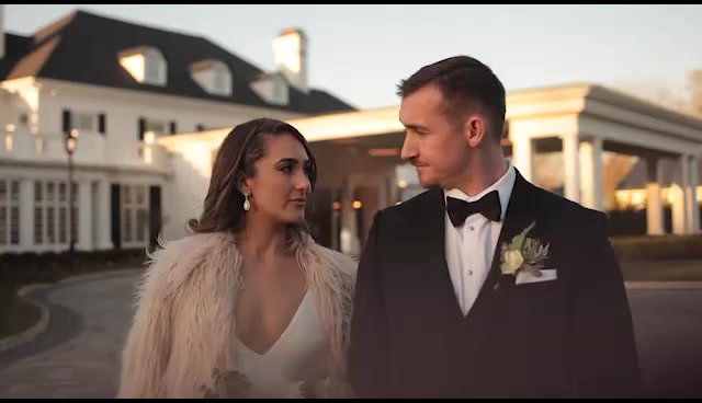 A couple in front of the mansion at golden hour