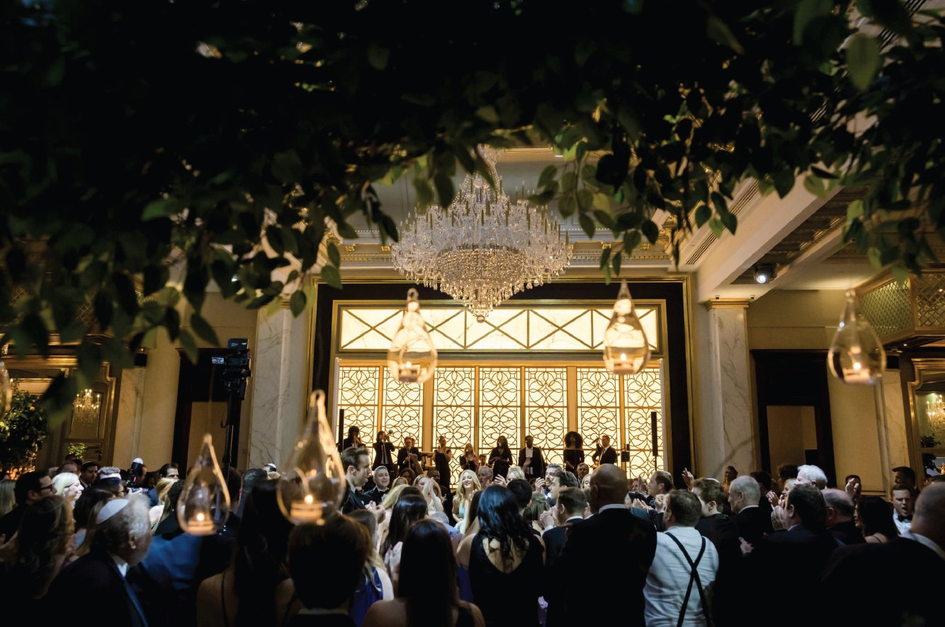 Guests celebrating beneath an illuminated arch at night