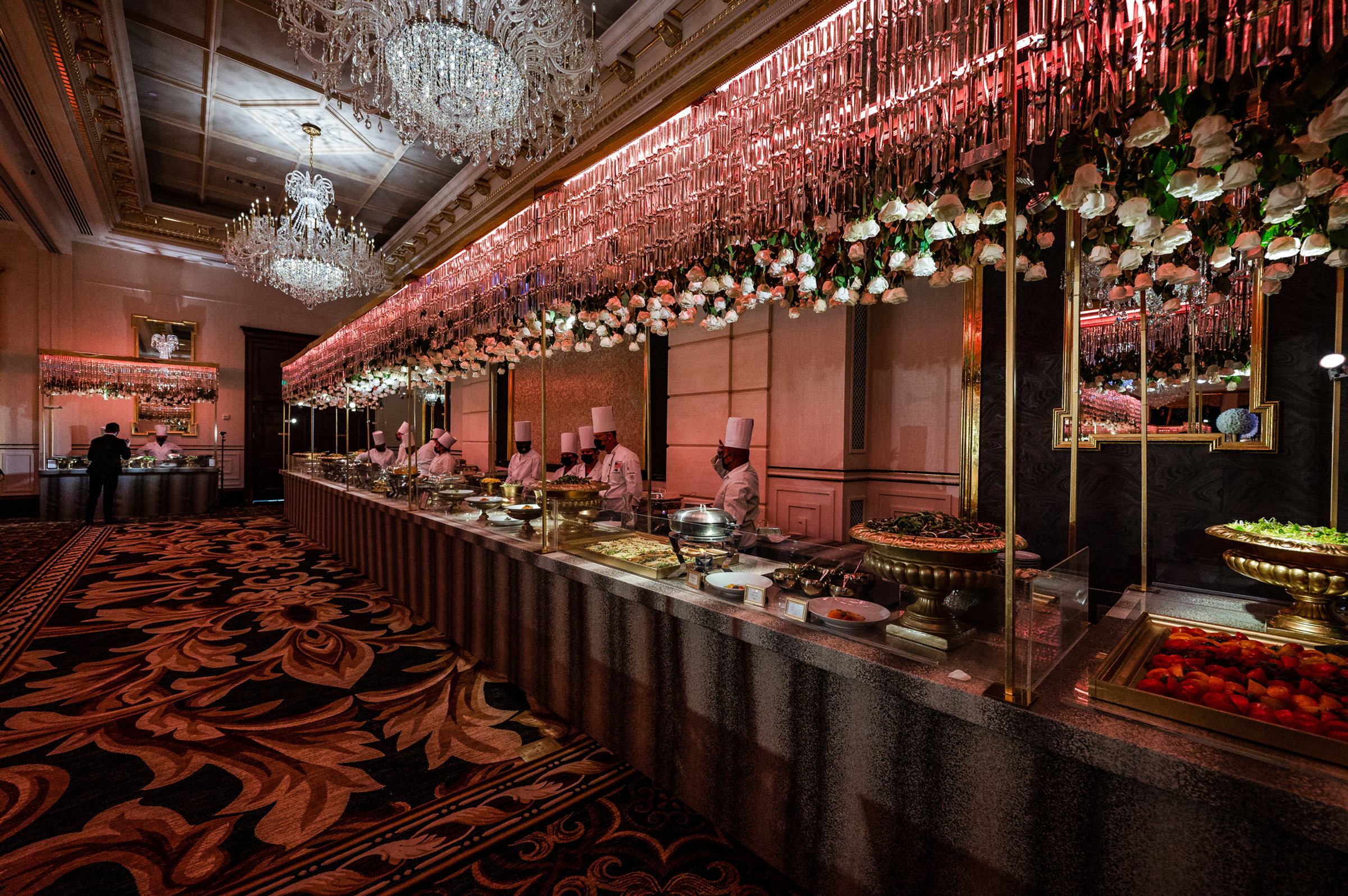 A dessert bar beneath a cascade of pink blossoms