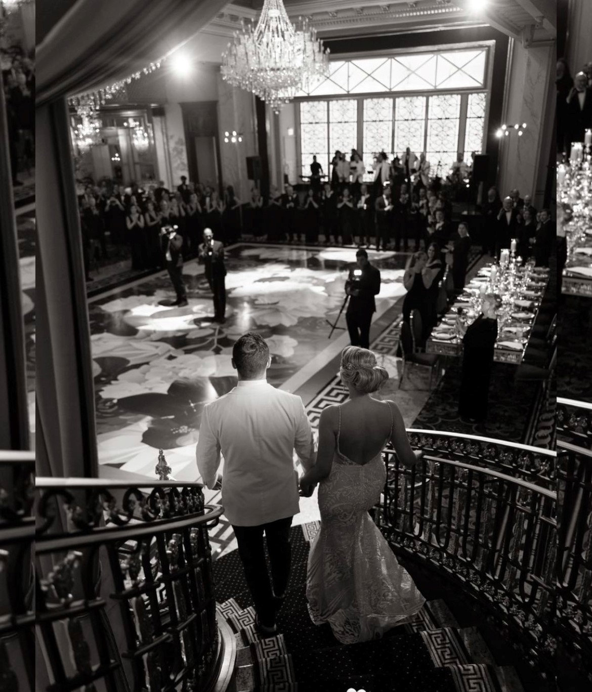 A couple descending the grand staircase, black and white