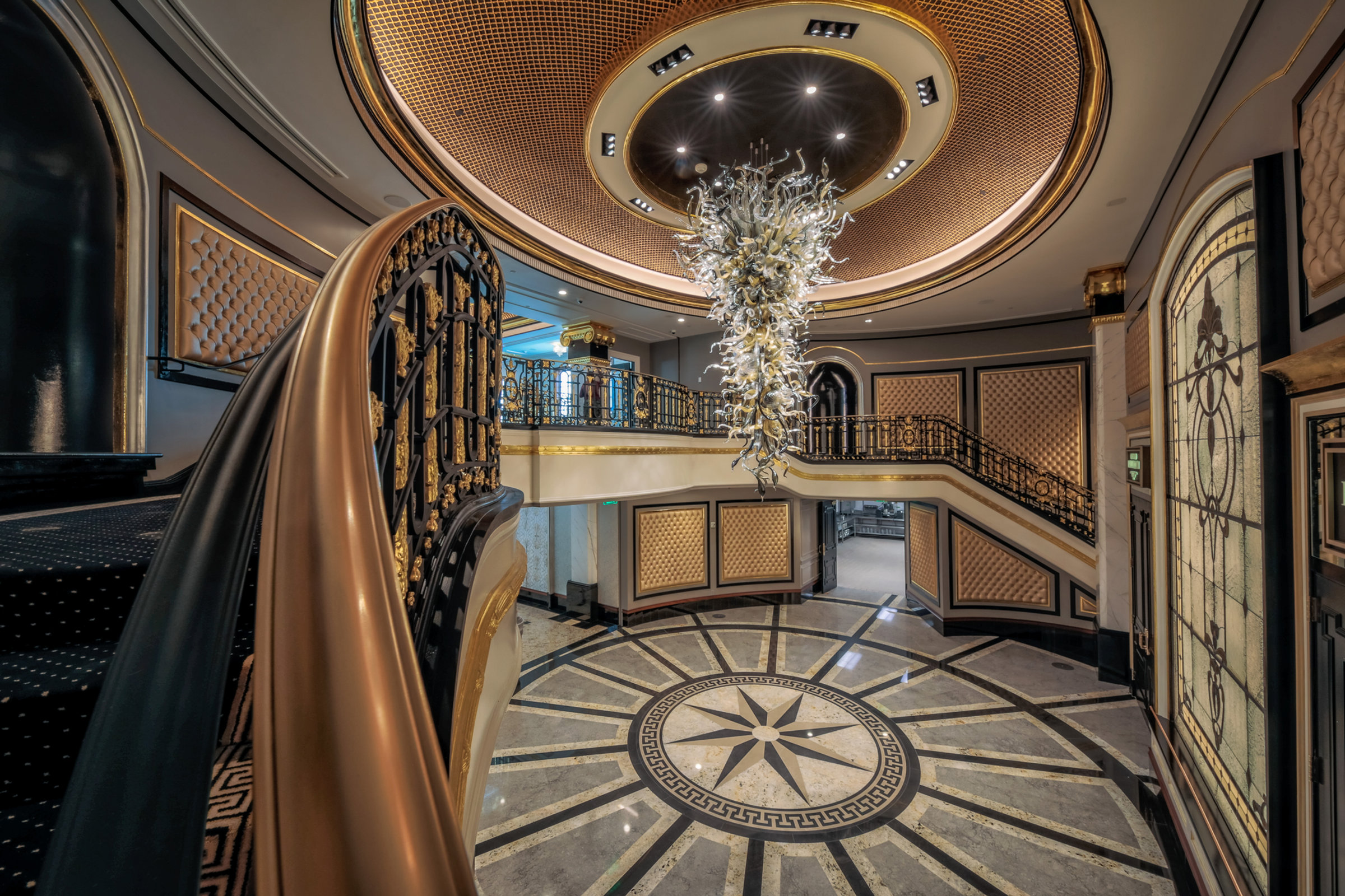 The curved staircase and compass-inlaid marble floor