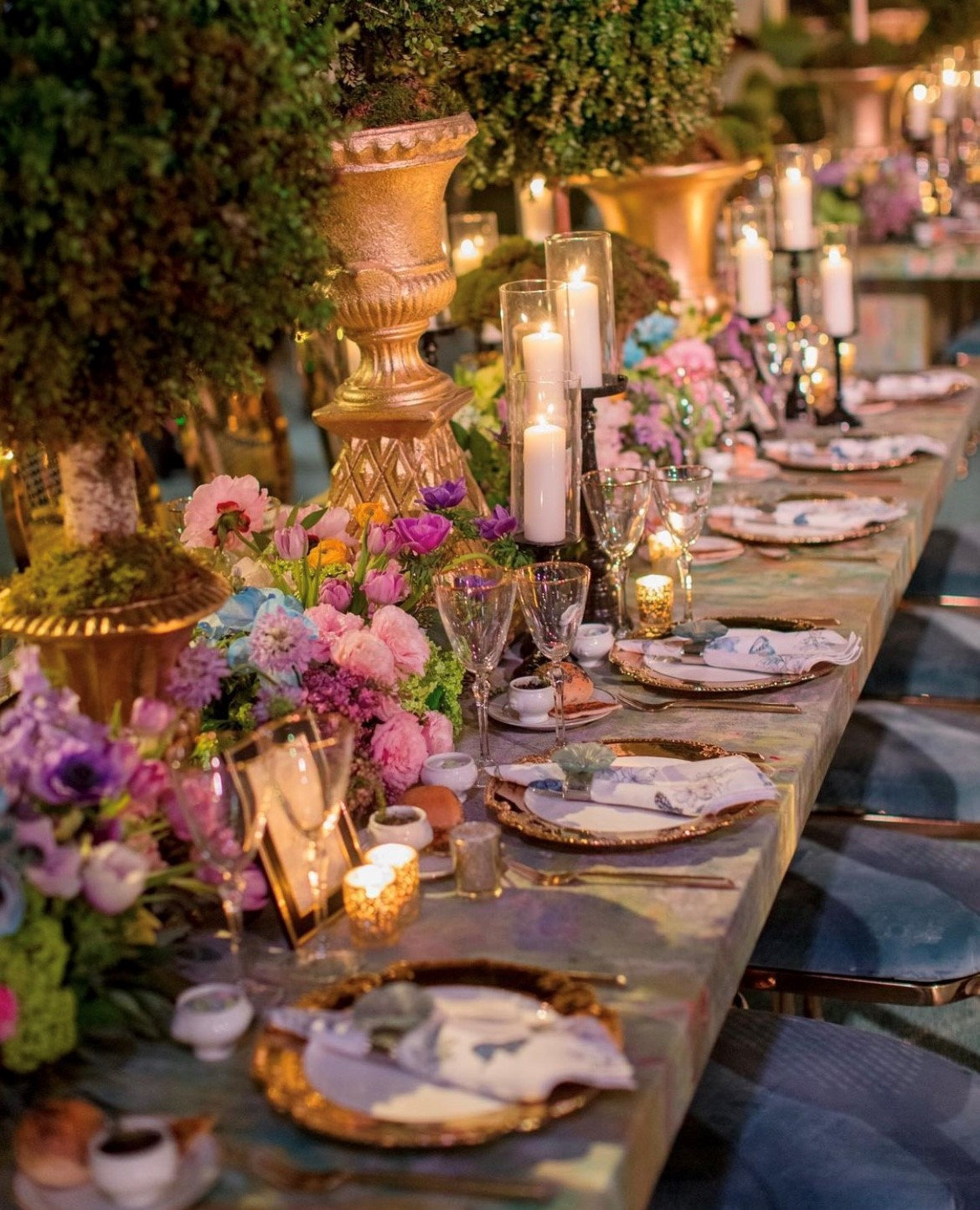 A candlelit tablescape with garden florals and gold chargers